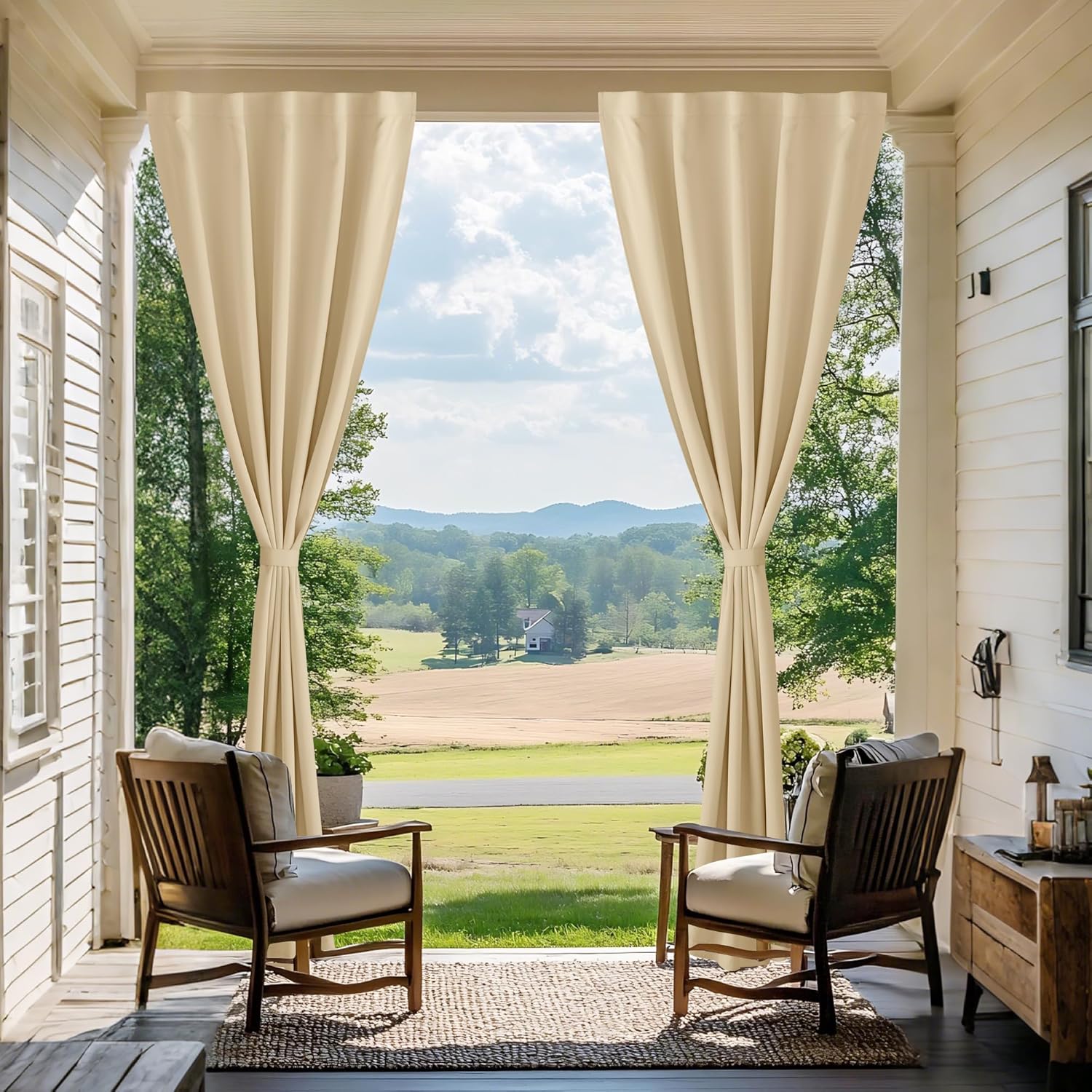 Beige waterproof outdoor curtains with Velcro tops tied back on a porch, framing a picturesque landscape view.