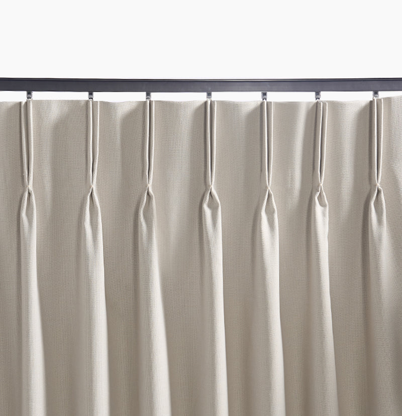 Custom heavy-duty metal curtain track with a magnetic closing, holding tailored beige pleated outdoor curtains for pergolas or patios.