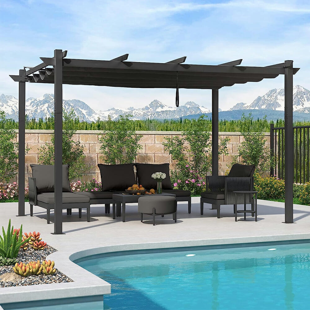 Outdoor patio with dark retractable pergola canopy fabric replacement extended, shading furniture by a pool, offering UPF 50+ protection.