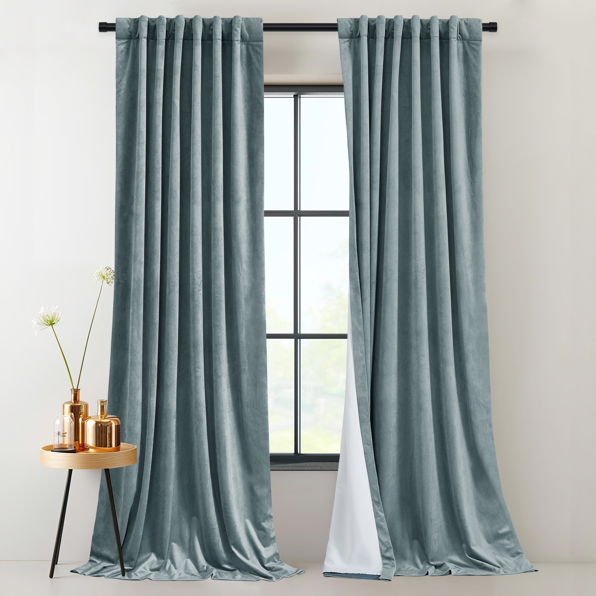 Two teal velvet rod pocket & back tab drapes show their thick, 2-layer thermal insulated light blocking lining.