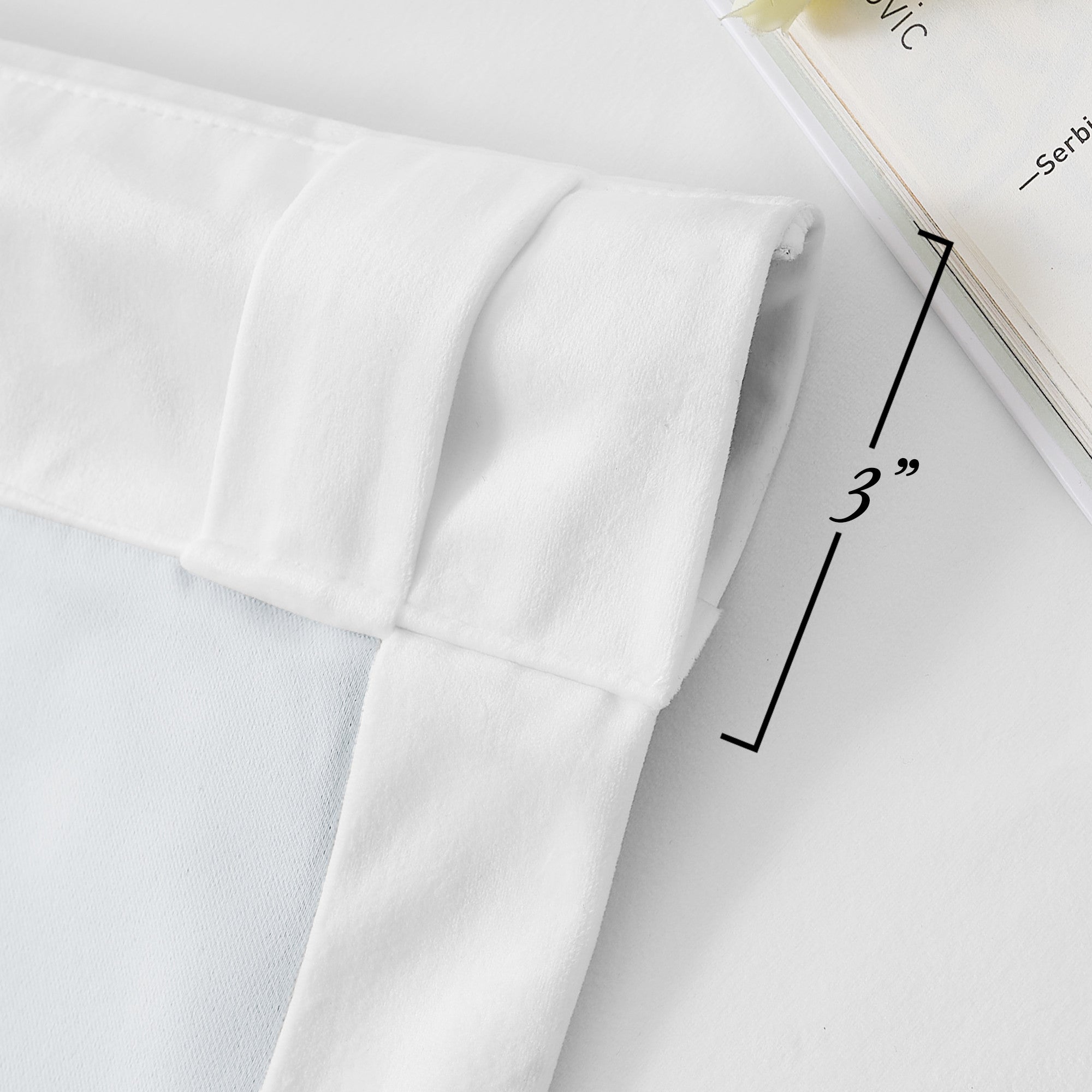 Close-up of white velvet curtain showing 3" rod pocket and back tab header detail for thick, thermal insulated drapes.