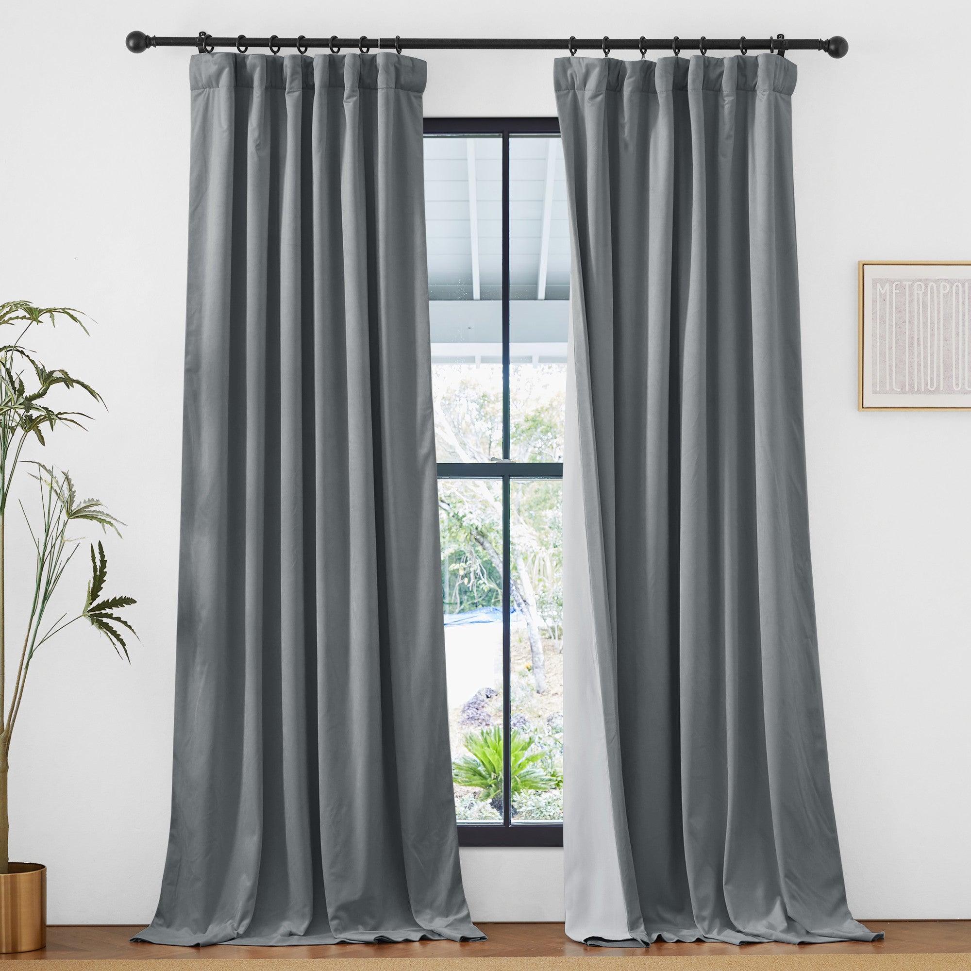 Luxurious grey velvet 2-layer thermal insulated light blocking drapes with rod pocket & back tab on a window, revealing outdoor greenery.