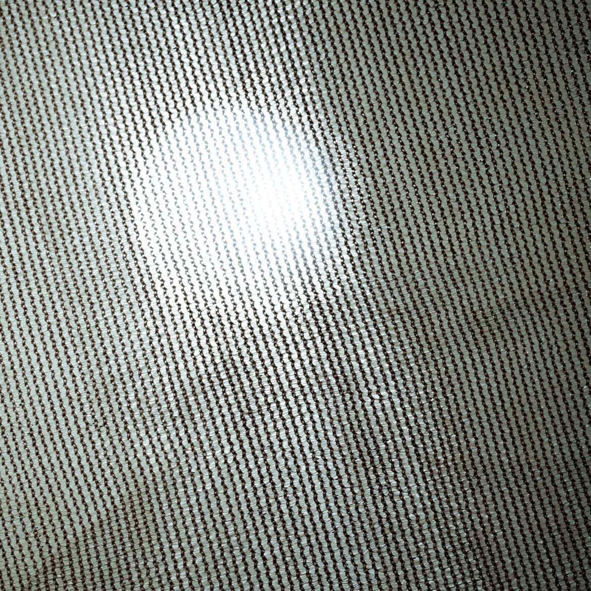 Textured close-up of custom breathable HDPE sun shade sail fabric, demonstrating UV block weave and light diffusion.