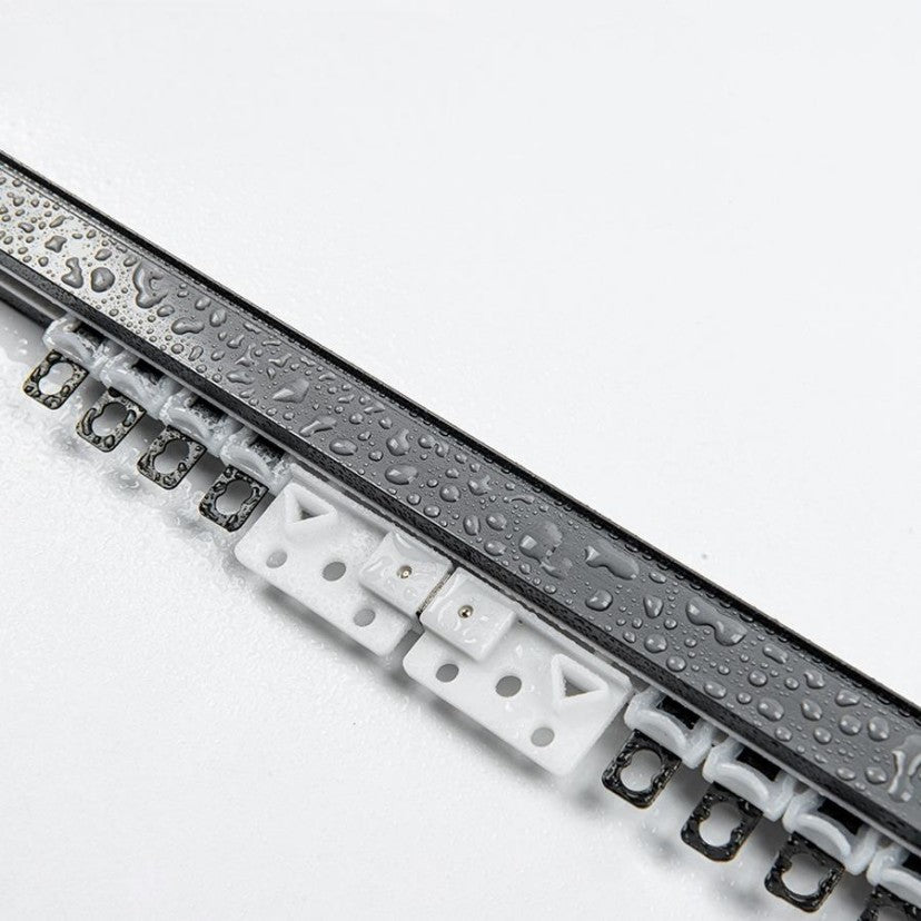 Close-up of heavy-duty metal outdoor curtain track covered in water droplets, featuring curtain gliders. Shows weatherproof quality.