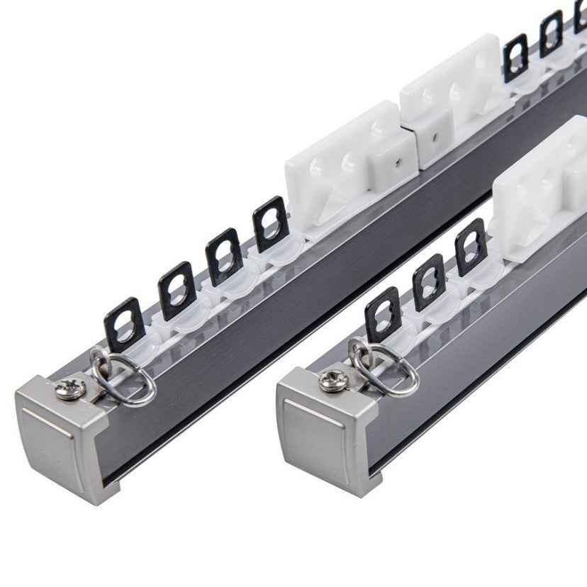 Close-up of heavy-duty metal curtain track with smooth white glides, black hooks, and silver end caps.