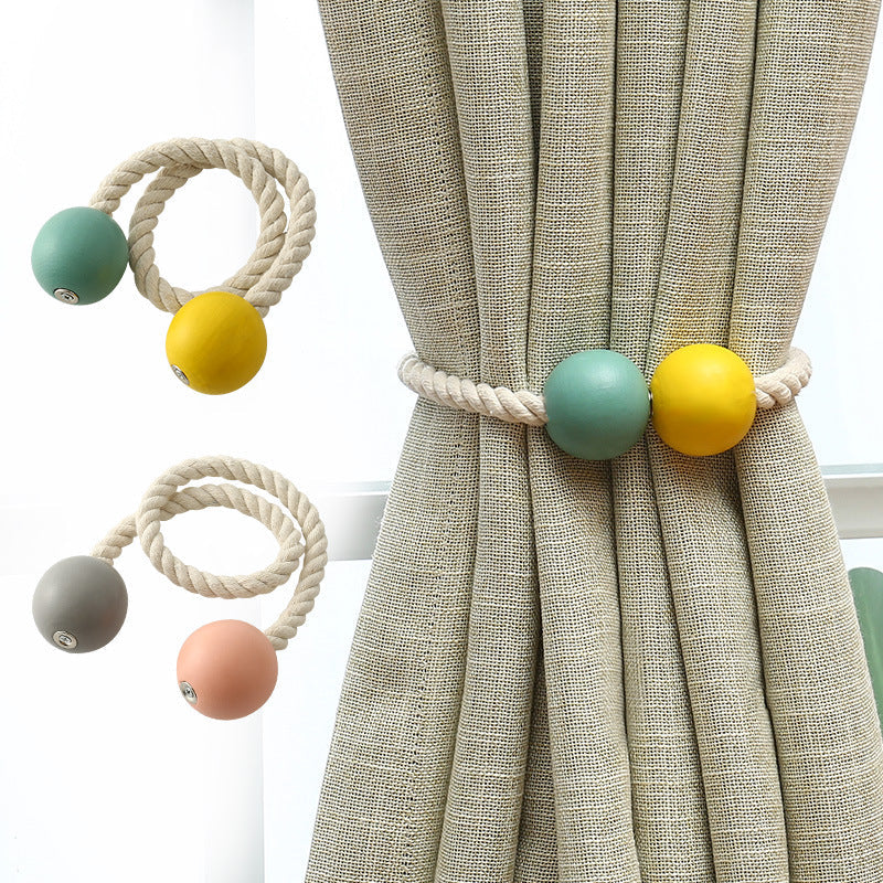 Decorative magnetic cotton hand-woven rope tieback with teal & yellow balls holding a beige outdoor curtain.