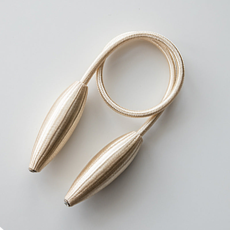 Simple modern beige curtain tieback with flexible coiled cord and elegant ribbed oval ends, perfect for outdoor or indoor curtains.