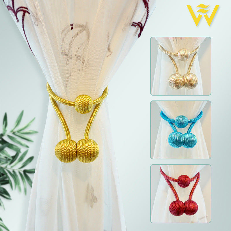 Golden magnetic curtain tieback holding sheer window curtain, shown with beige, blue, and red decorative modern ball design tiebacks.