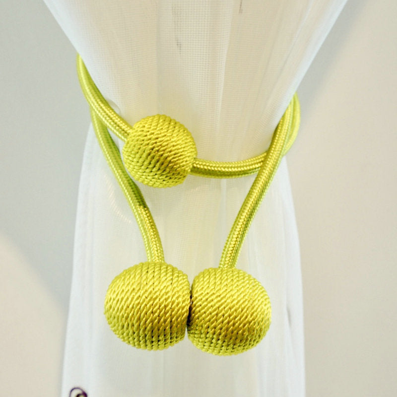 Vibrant lime green magnetic curtain tieback with textured woven ball ends elegantly cinching a white sheer curtain, showcasing its simple, modern design.