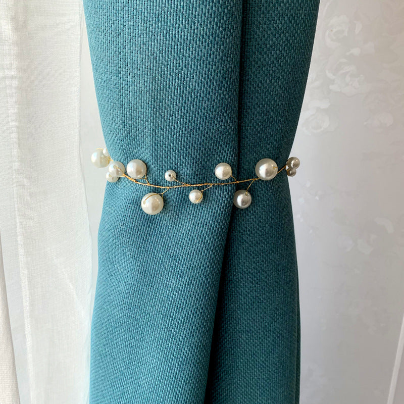 Elegant gold alloy pearl curtain tieback securing a textured teal outdoor curtain, perfect for patio or pergola.