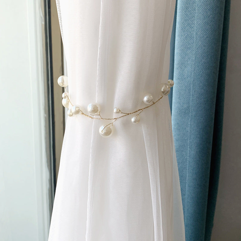 Decorative alloy pearl curtain tieback with gold wire and white pearls, holding a sheer white window curtain.