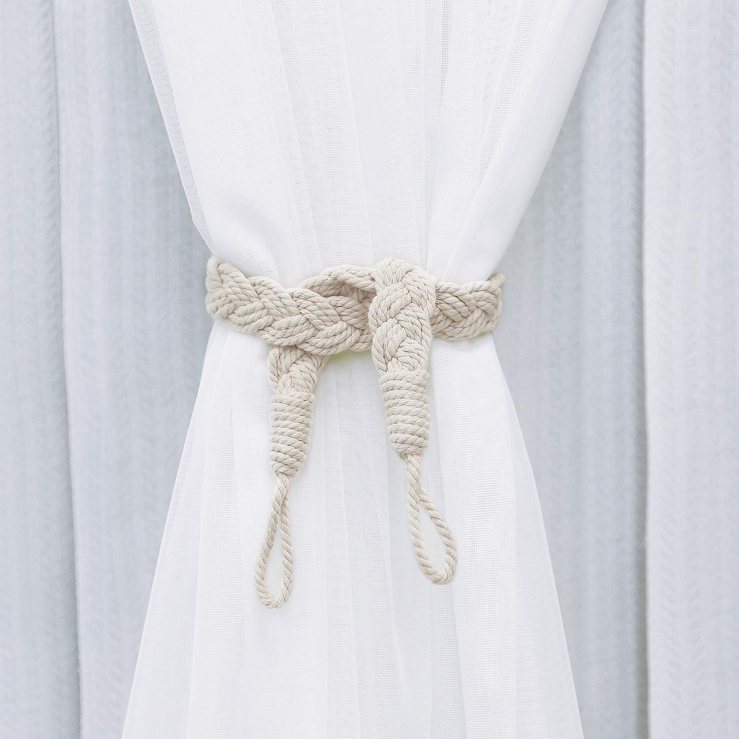 Beige braided cotton rope tieback in a vintage style, cinching a white sheer outdoor curtain. Handmade holdback for pergolas & lanais.