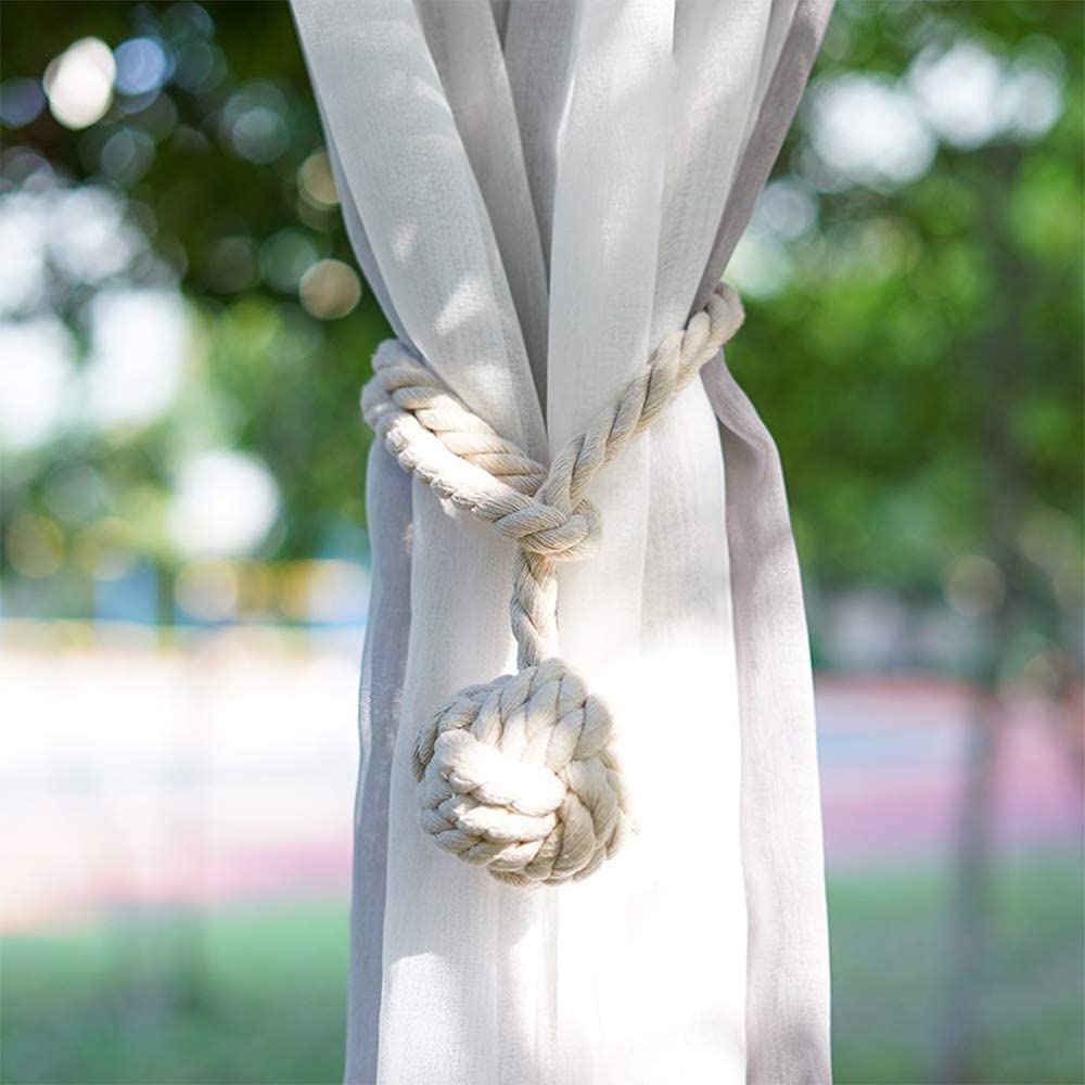 Macrame rope tieback with decorative knot securing a sheer white outdoor curtain. Ideal for patios, pergolas, or pool areas.