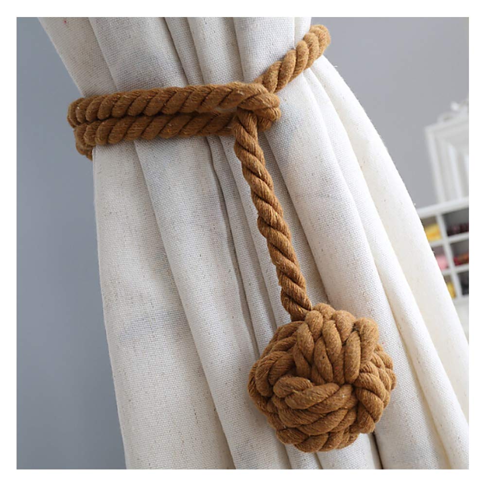 Thick braided brown rope curtain tieback with a decorative nautical sphere knot holding an off-white outdoor patio curtain.