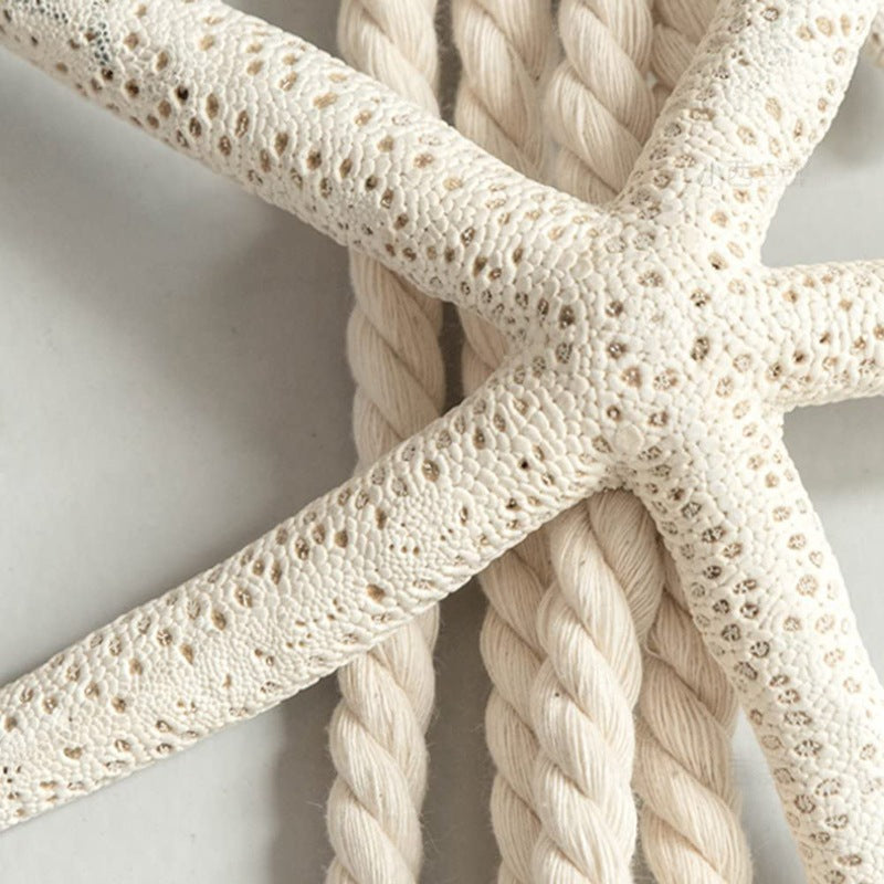 Natural white starfish decoration strap with textured arms against braided rope, perfect for outdoor curtain tiebacks.