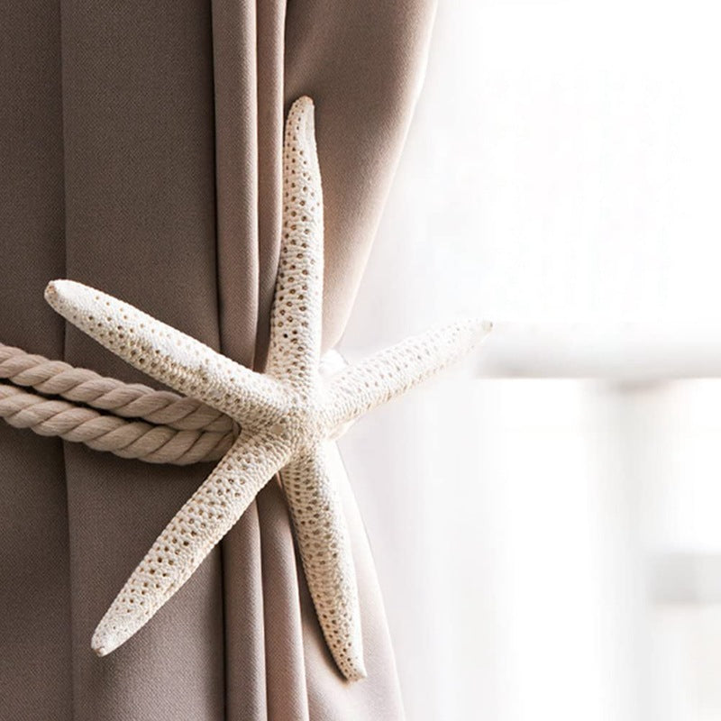 Decorative natural starfish curtain tieback with nautical rope holding a Fadenomore™ outdoor curtain. Enhances patio style.