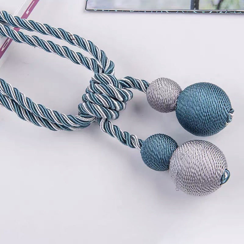 Decorative teal & silver braided rope magnetic ball curtain tiebacks, knotted, for stylish window treatments & accessories.