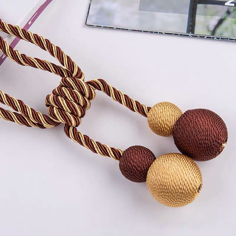 Elegant brown and gold twisted rope magnetic ball curtain tieback for window treatments and outdoor curtains.