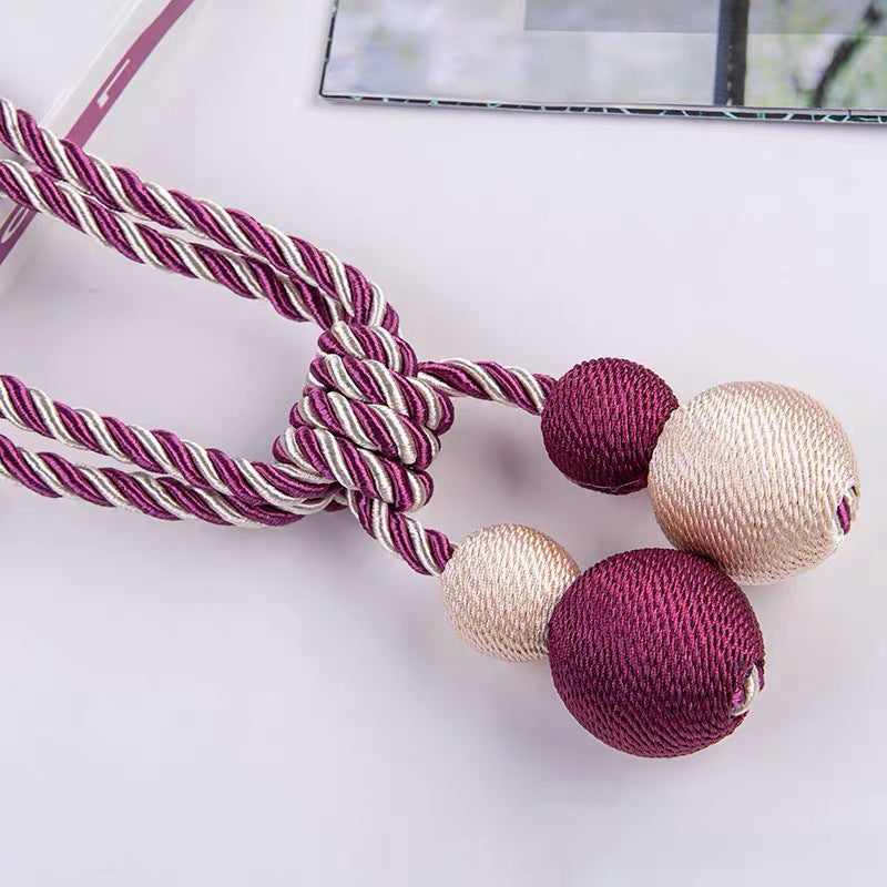 Stylish purple & silver twisted rope magnetic curtain tieback with two deep purple and two light beige decorative ball ends for window treatments.