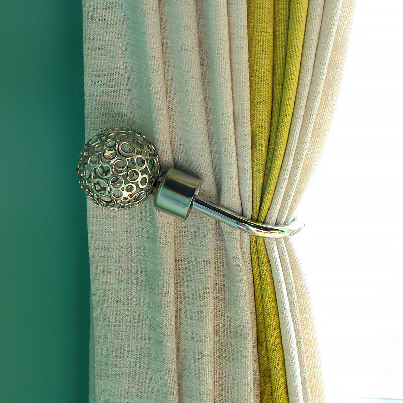 Decorative metallic sphere U-shaped hollow curtain buckle hook tieback cinching cream and green outdoor curtains.