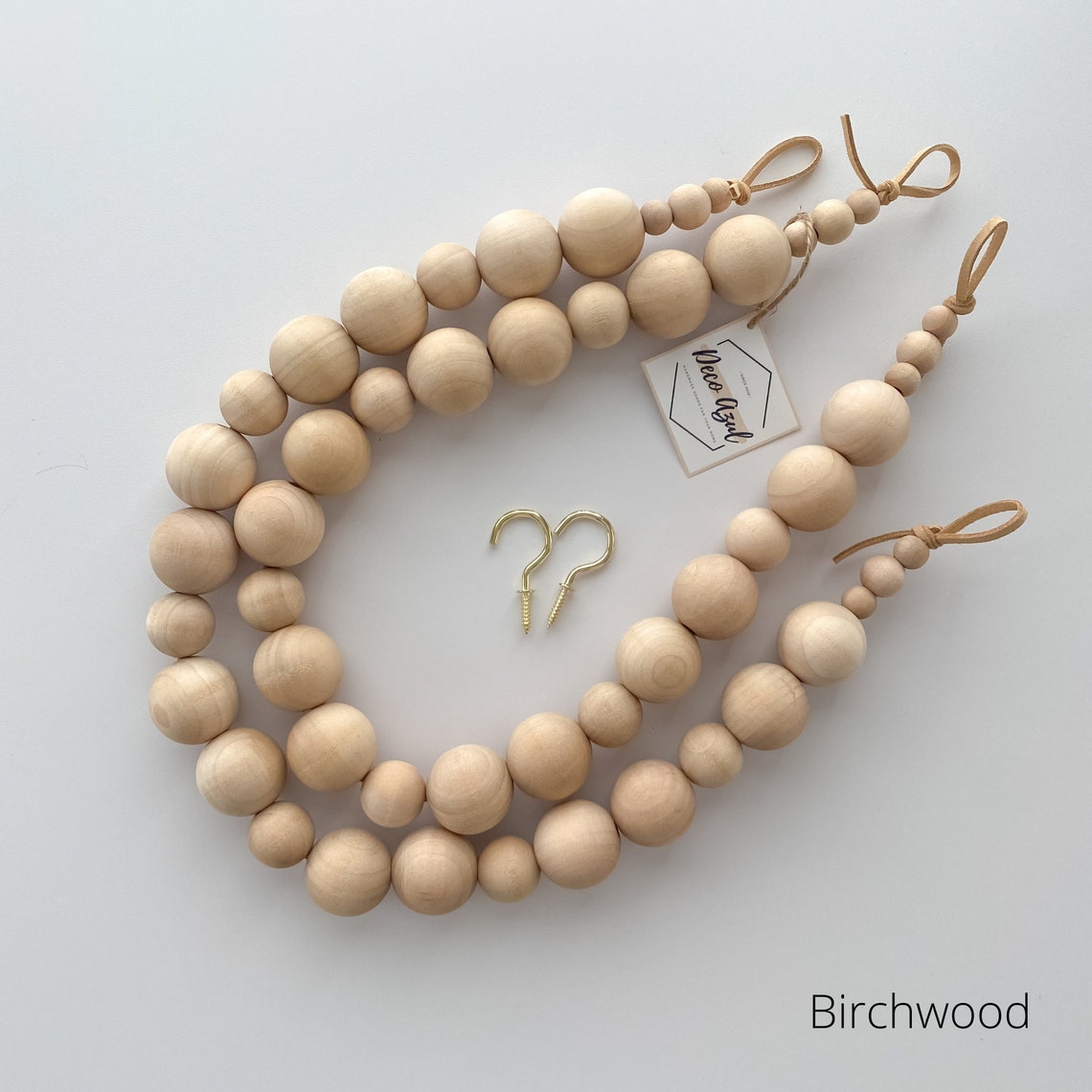Pair of natural birchwood wooden bead curtain straps and tiebacks with leather loops and gold hooks.