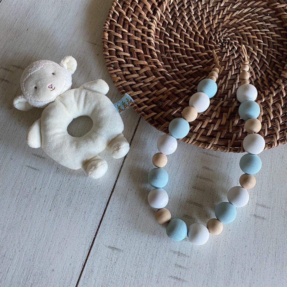Single wooden beads curtain tieback featuring light blue, white, & natural wood spheres. Perfect for outdoor curtains.