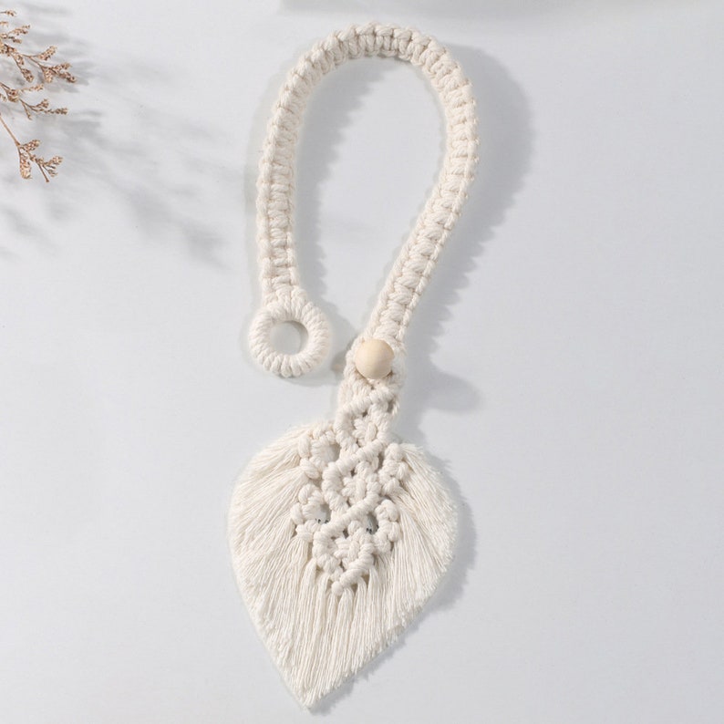 White macrame leaf design curtain tieback featuring a wooden bead and loop closure, ideal for KGORGE outdoor patio curtains.