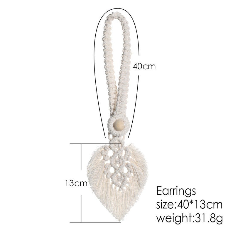 Cream macrame leaf design curtain tieback with a braided loop and wooden bead. Decorative boho accessory for outdoor or indoor patio curtains.