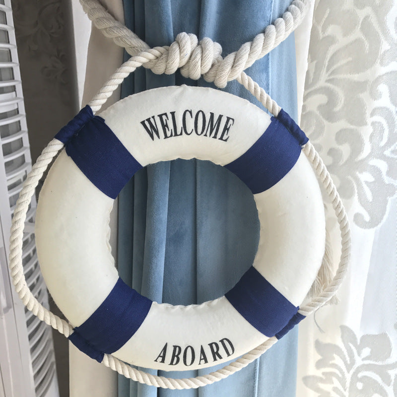 Nautical rope curtain tieback featuring a white and blue 'WELCOME ABOARD' lifebuoy, bundling blue drapes.