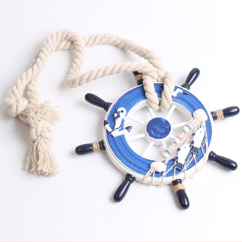 Nautical blue ship wheel decor with anchor, fish, and shells. Woven rope curtain tieback for bundling curtains.