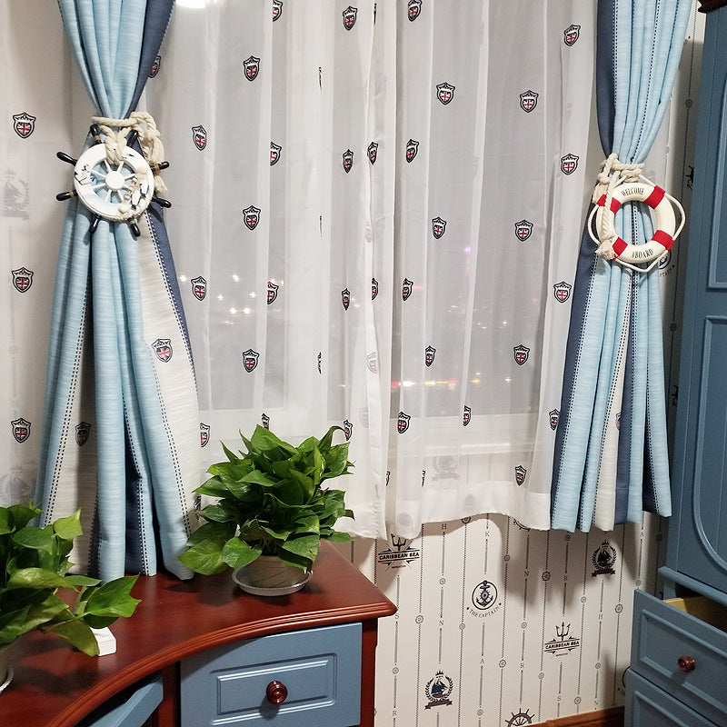 Nautical rope curtain tiebacks: ship wheel & life preserver clips bundling blue striped curtains.