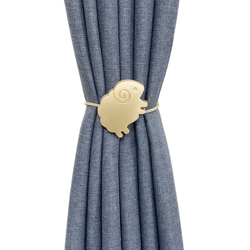 Gold sheep magnetic curtain tieback securing a pleated blue outdoor curtain.