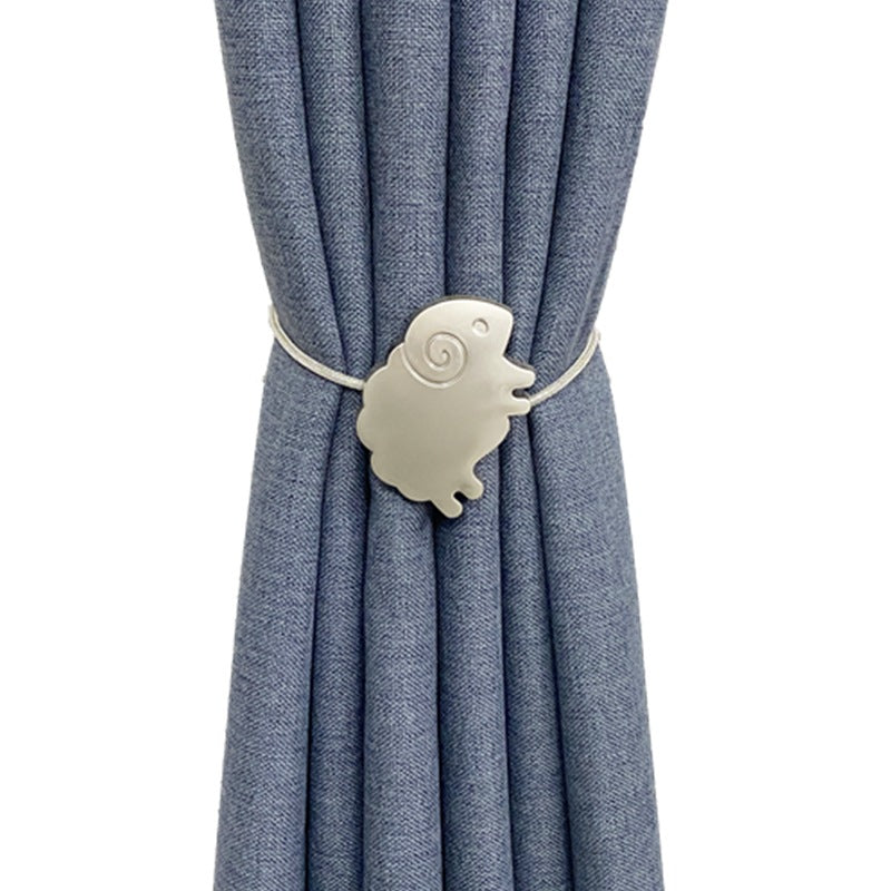 Silver sheep magnetic curtain tieback holding back a blue outdoor curtain, adding a decorative touch for patio or pergola.