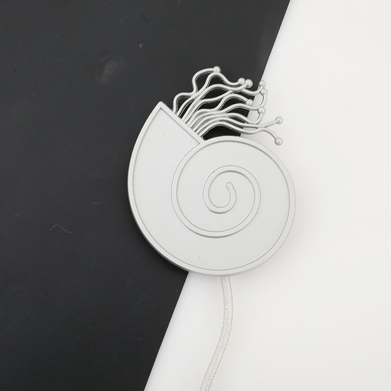 Silver cat head magnetic curtain tieback with spiral design, wavy whiskers, and braided metallic cord.