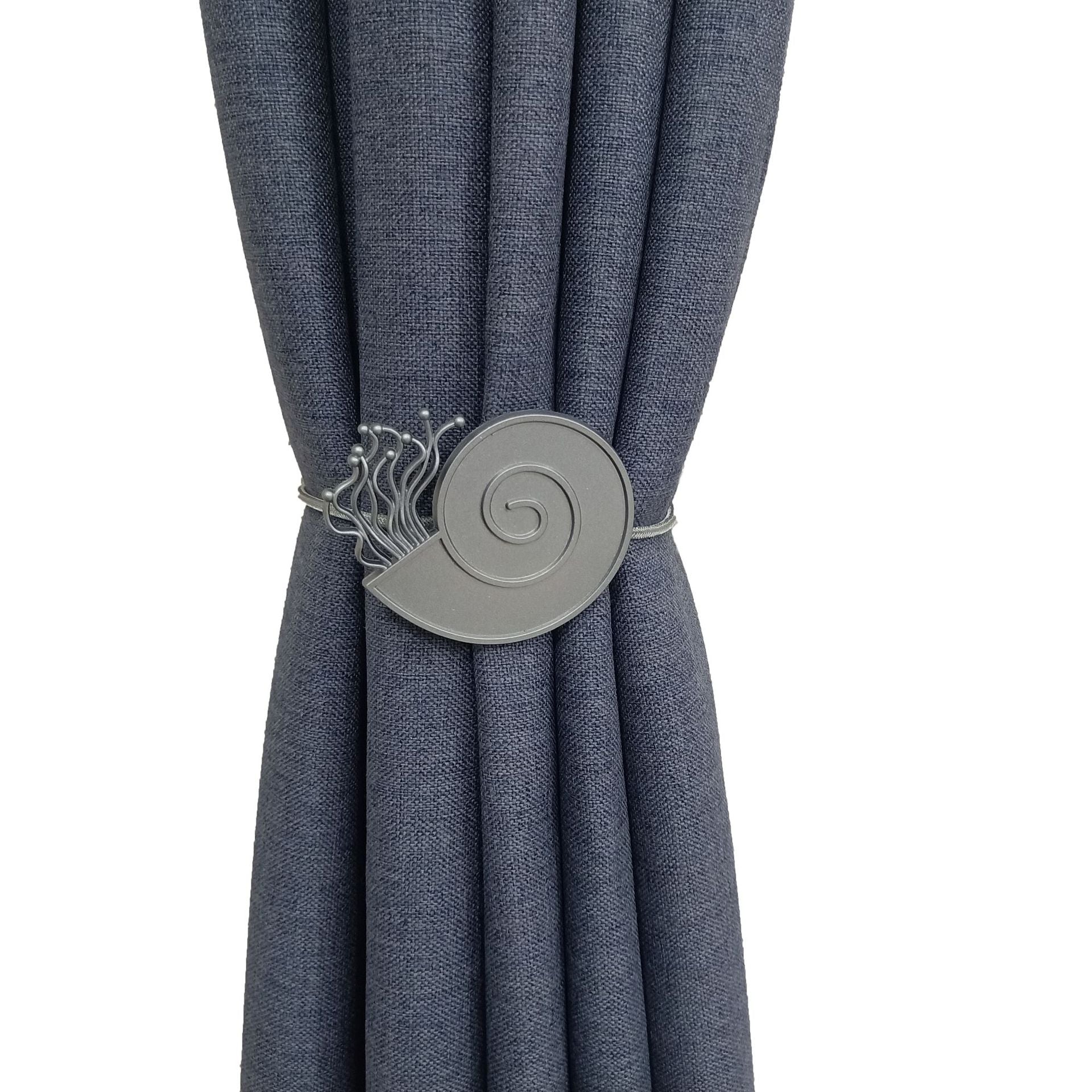 Navy blue textured outdoor curtain held back by a decorative silver snail shell magnetic curtain tieback. Enhances patio shade.