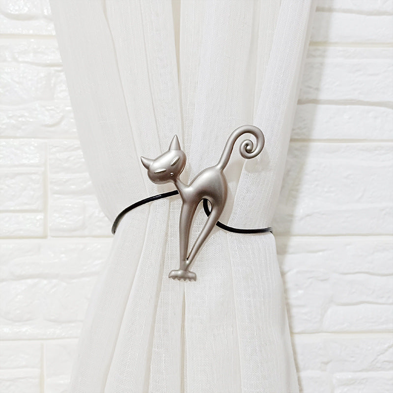 Decorative silver cat magnetic curtain tieback securing a white curtain panel, perfect for patio or pergola shade solutions.