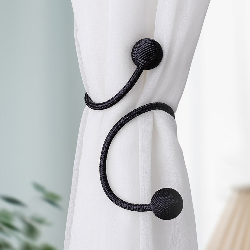 Modern black magnetic curtain tieback strap featuring braided rope texture, holding a white sheer panel for simple elegant decor.