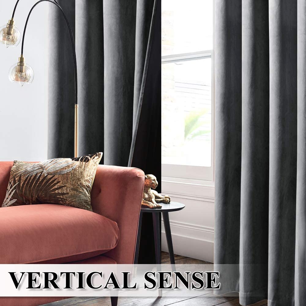 Two panels of gray velvet rod pocket drapes with blackout lining, effectively darkening a living room window next to a sofa.