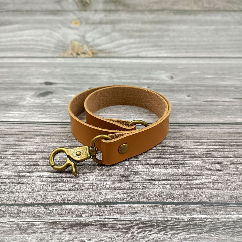 Light brown leather curtain tieback strap with antique brass buckle & rivet, ideal decoration accessory for outdoor curtains.