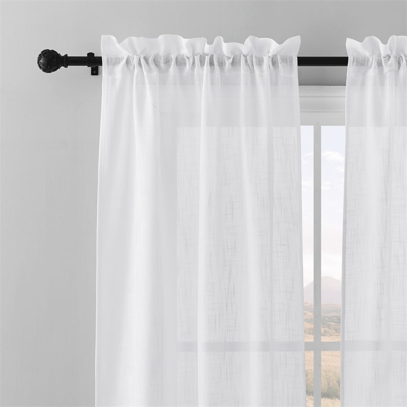 Close-up of black adjustable extra-long outdoor curtain rod with decorative petal ball finial holding a white outdoor curtain.