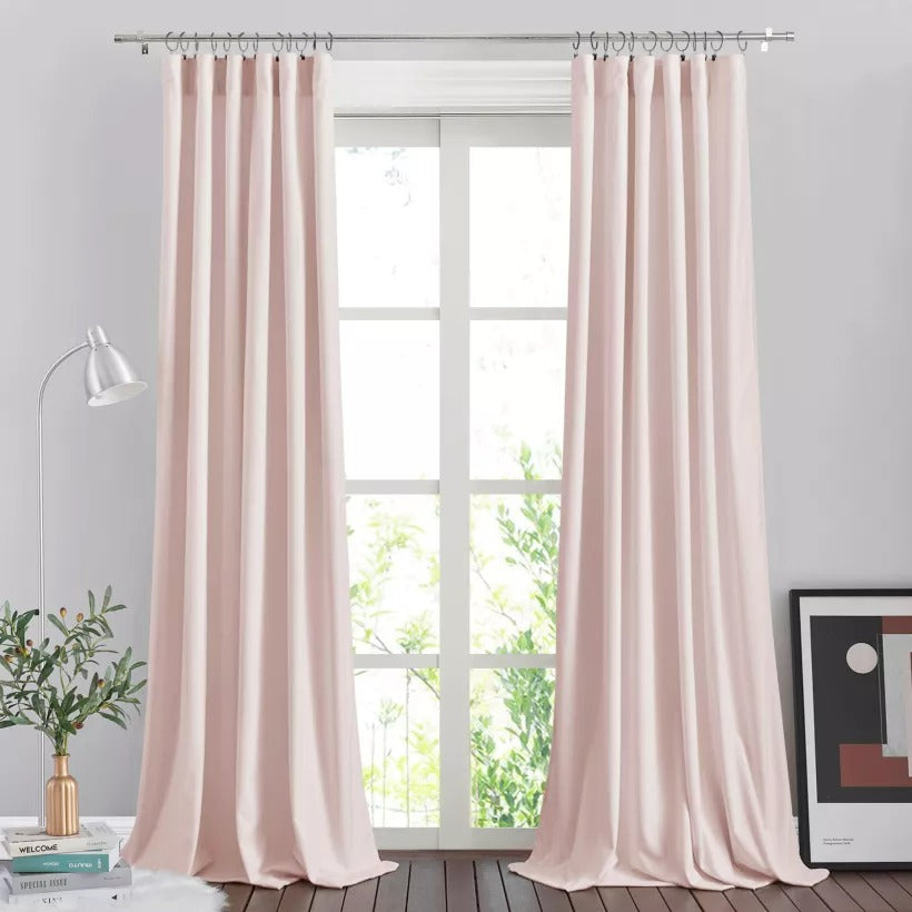 Silver brushed finial indoor/outdoor curtain rod holding blush panel curtains, creating a soft shade solution for a window.