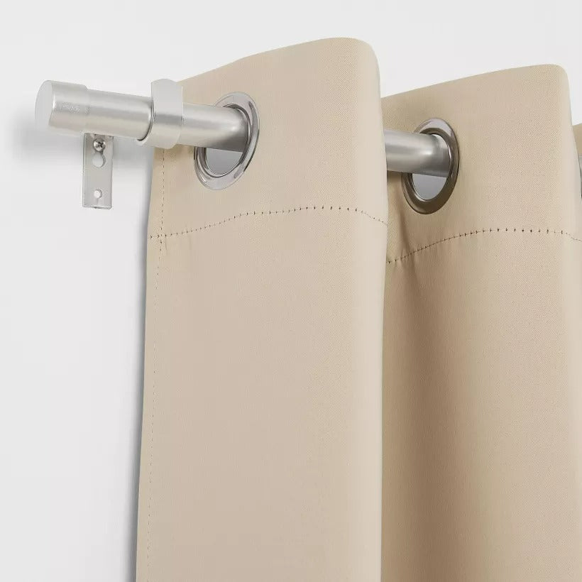 Brushed finial indoor/outdoor curtain rod with a beige weatherproof grommet curtain, perfect for patio or pergola.