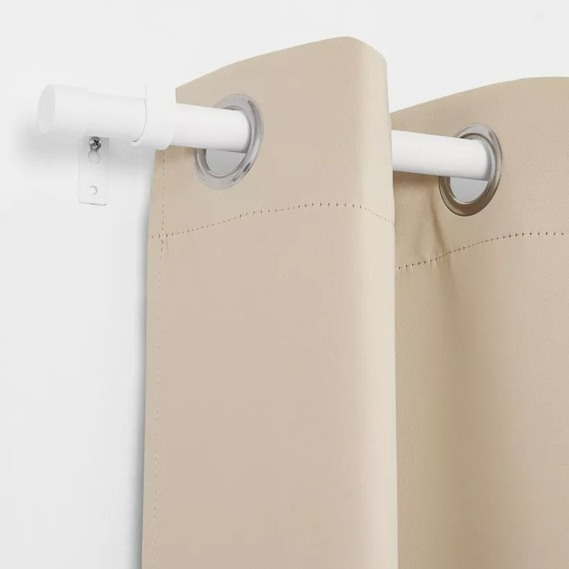 Beige weatherproof outdoor curtain with silver grommets on a white brushed finial indoor/outdoor curtain rod. Perfect for patio shade.