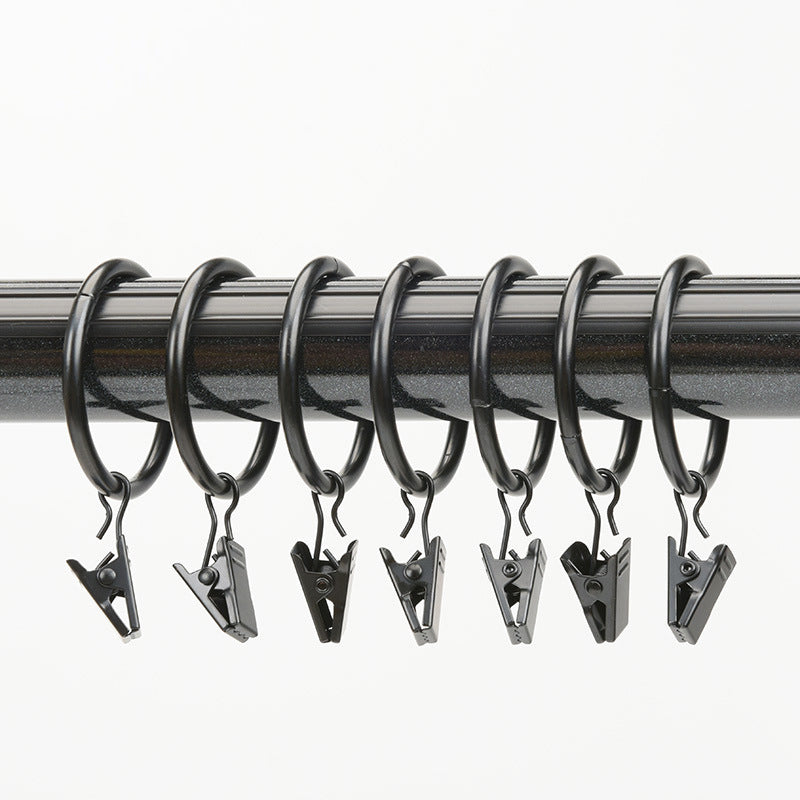 Close-up of black 1.7in diameter curtain rings with clips on a rod, ideal for hanging indoor bedroom or living room curtains.