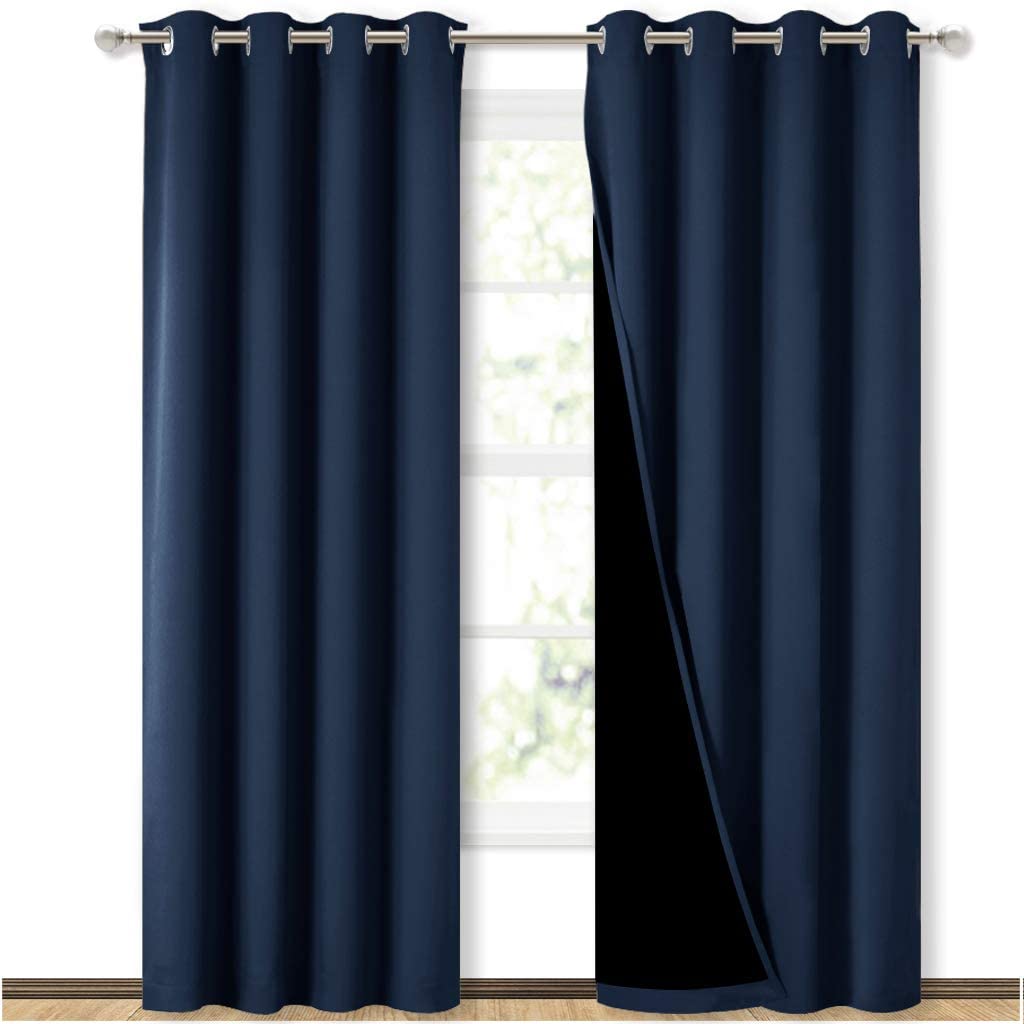 Dark blue double layer grommet blackout curtains for sliding glass doors, one panel open revealing the inner black room darkening liner.