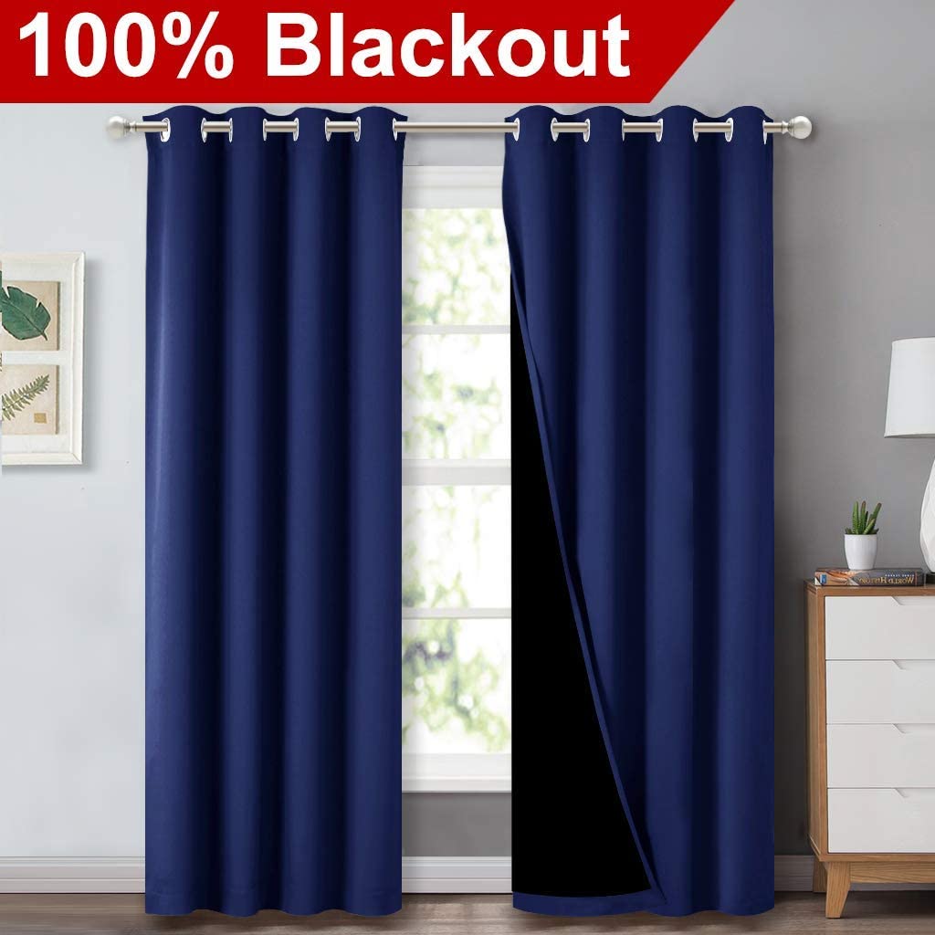 Two navy blue double layer grommet blackout curtains for sliding glass door, one revealing black inner layer.