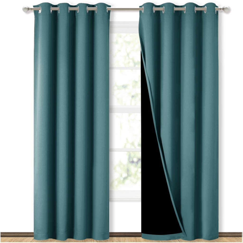 Two teal double-layer grommet blackout curtains for sliding glass doors, one panel pulled back showing black lining.