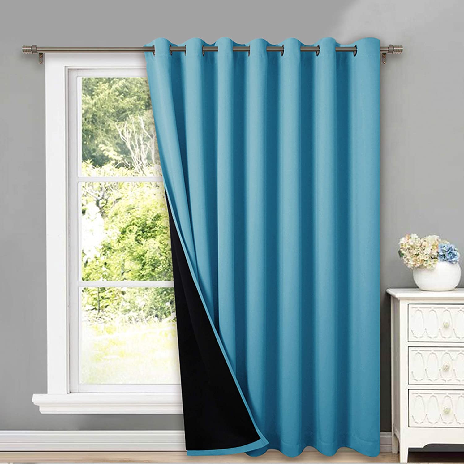 Teal double layer grommet blackout curtain with black thermal insulated lining, partially covering a living room or bedroom window.