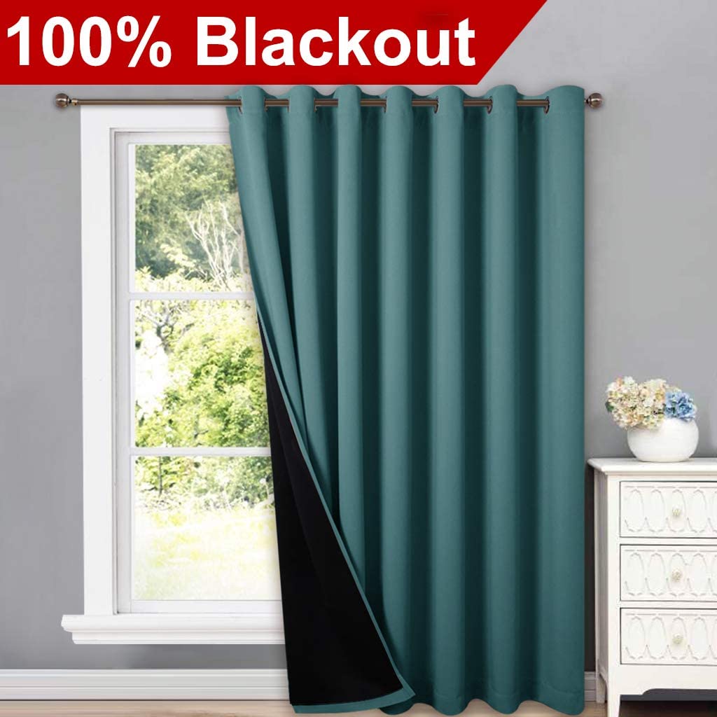 Teal double-layer thermal insulated blackout grommet curtain, partially open to reveal black lining, in a living room.