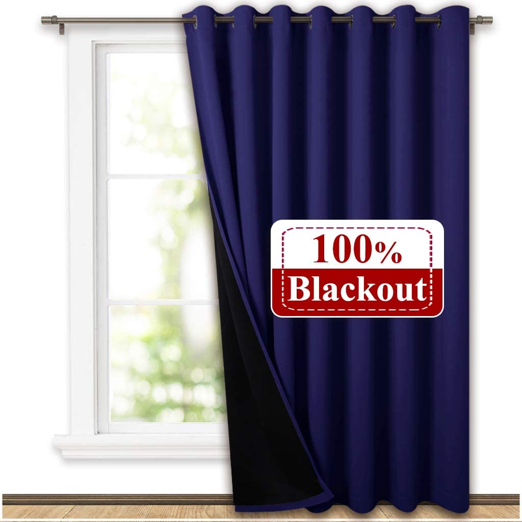 Navy blue double layer grommet thermal insulated blackout curtain with black lining, partially closed on a window. 100% blackout.